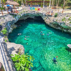 Clearwater pool made from a cave, with people enjoying the sun