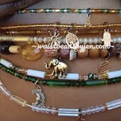 Multiple Waistbeads with charms, various colors, worn on a woman's belly
